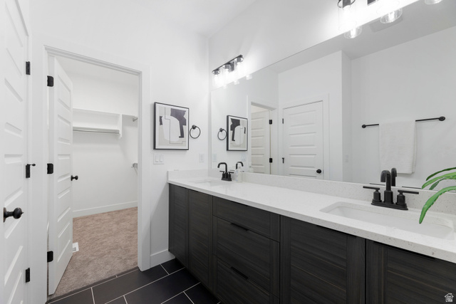 14392 South Champ Cove Draper, UT 84020 - Photo 17 of 31 Bathroom featuring double vanity, a spacious closet, dark colored carpet, and dark tile patterned floors