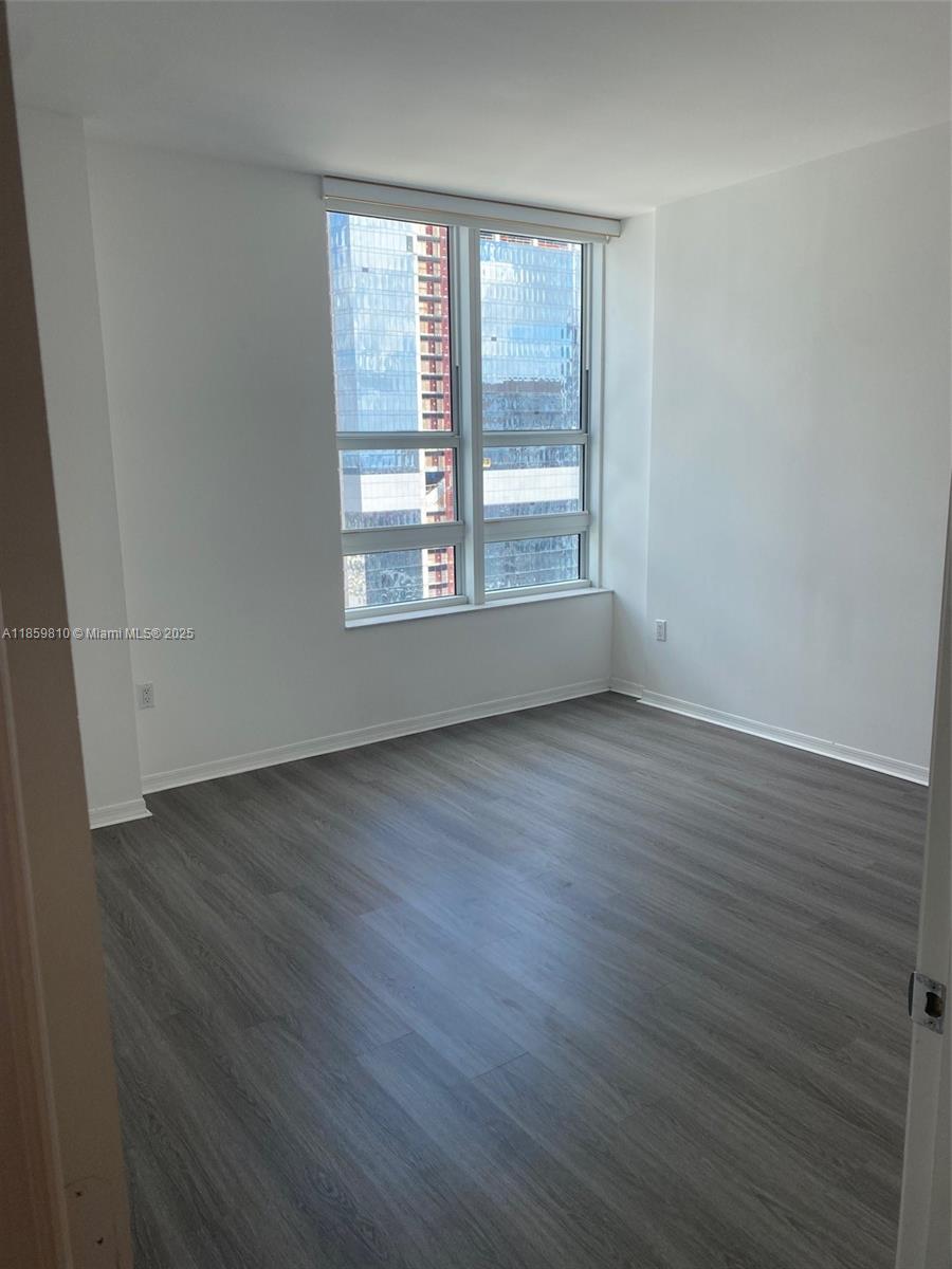 951 Brickell Avenue, Unit 3609 Miami, FL 33131 - Photo 13 of 25 an empty room with wooden floor and windows