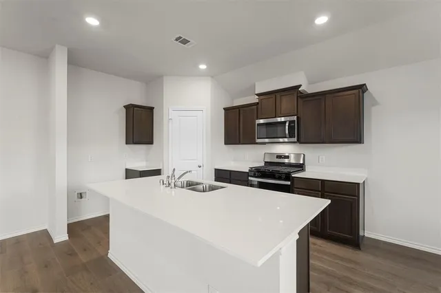 a kitchen that has a sink and a stove top oven