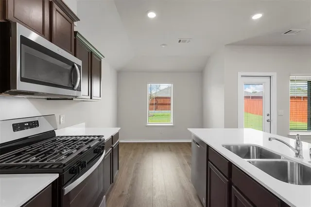 a kitchen with a sink a stove and cabinets