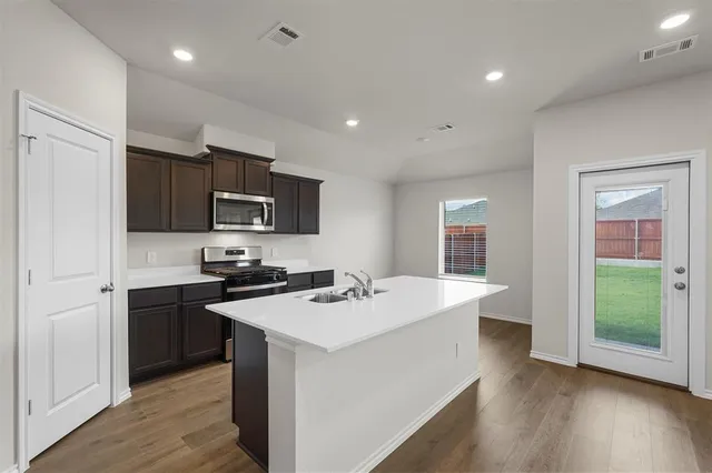 a kitchen with a sink stainless steel appliances and white cabinets
