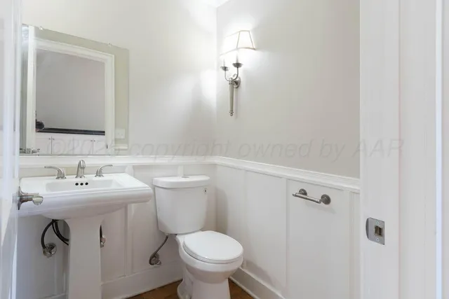 a bathroom with a toilet sink and mirror