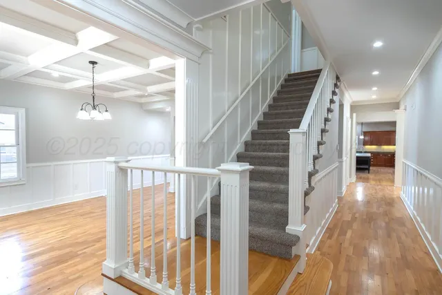 a view of a hallway with wooden floor and staircase