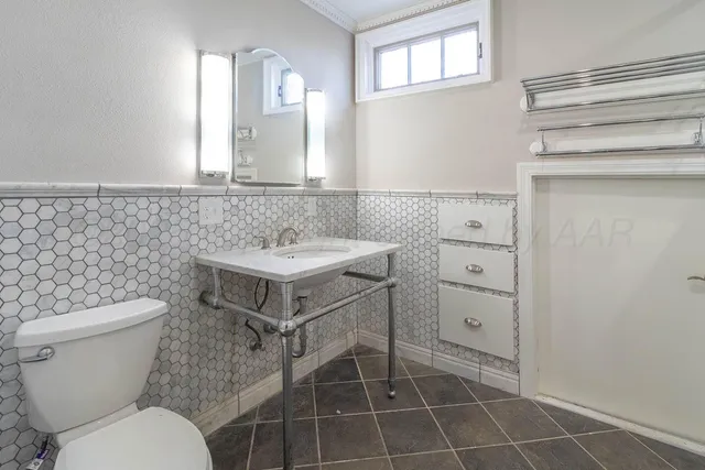 a bathroom with a granite countertop toilet sink and mirror