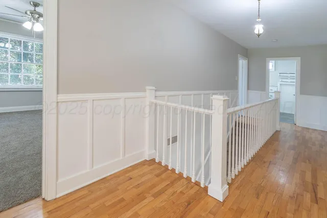 a view of a hallway with wooden floor and stairs