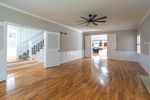 a view of a livingroom with wooden floor and a ceiling fan
