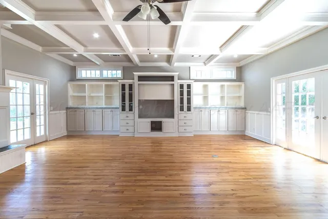 a view of empty room with wooden floor and fireplace