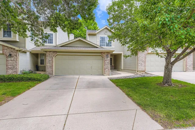 a front view of a house with a yard and trees