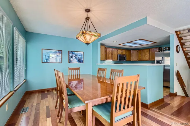 a dining room with furniture a chandelier and wooden floor