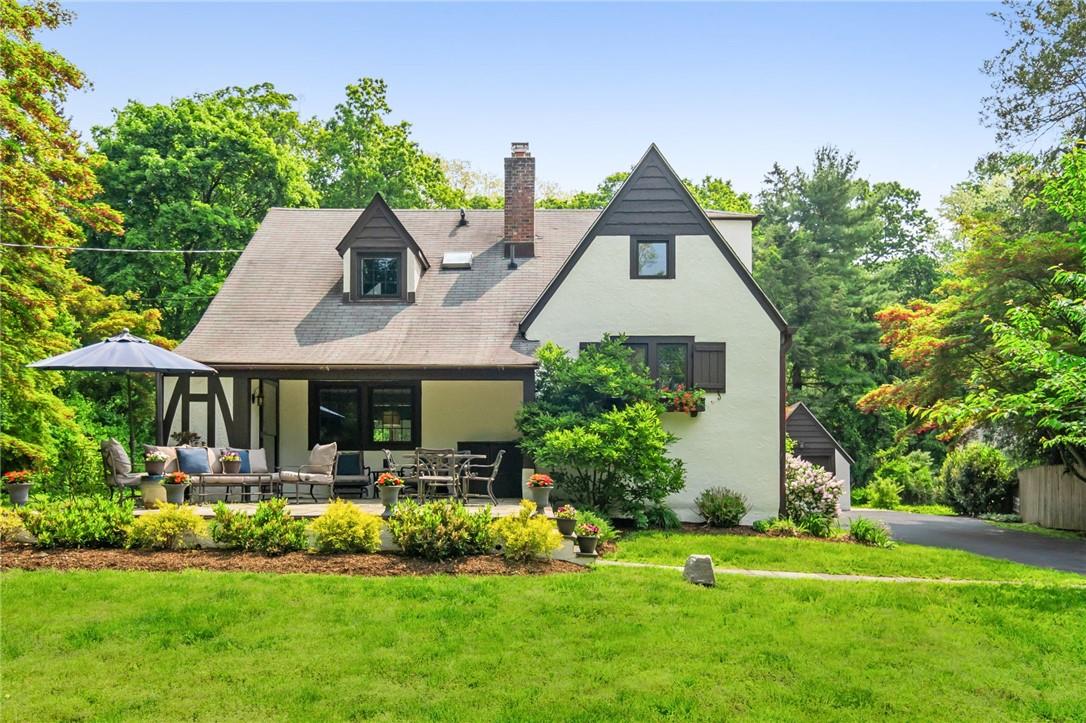 345 Quaker Road Chappaqua, NY 10514 - Photo 1 of 1 a front view of a house with a yard table and chairs