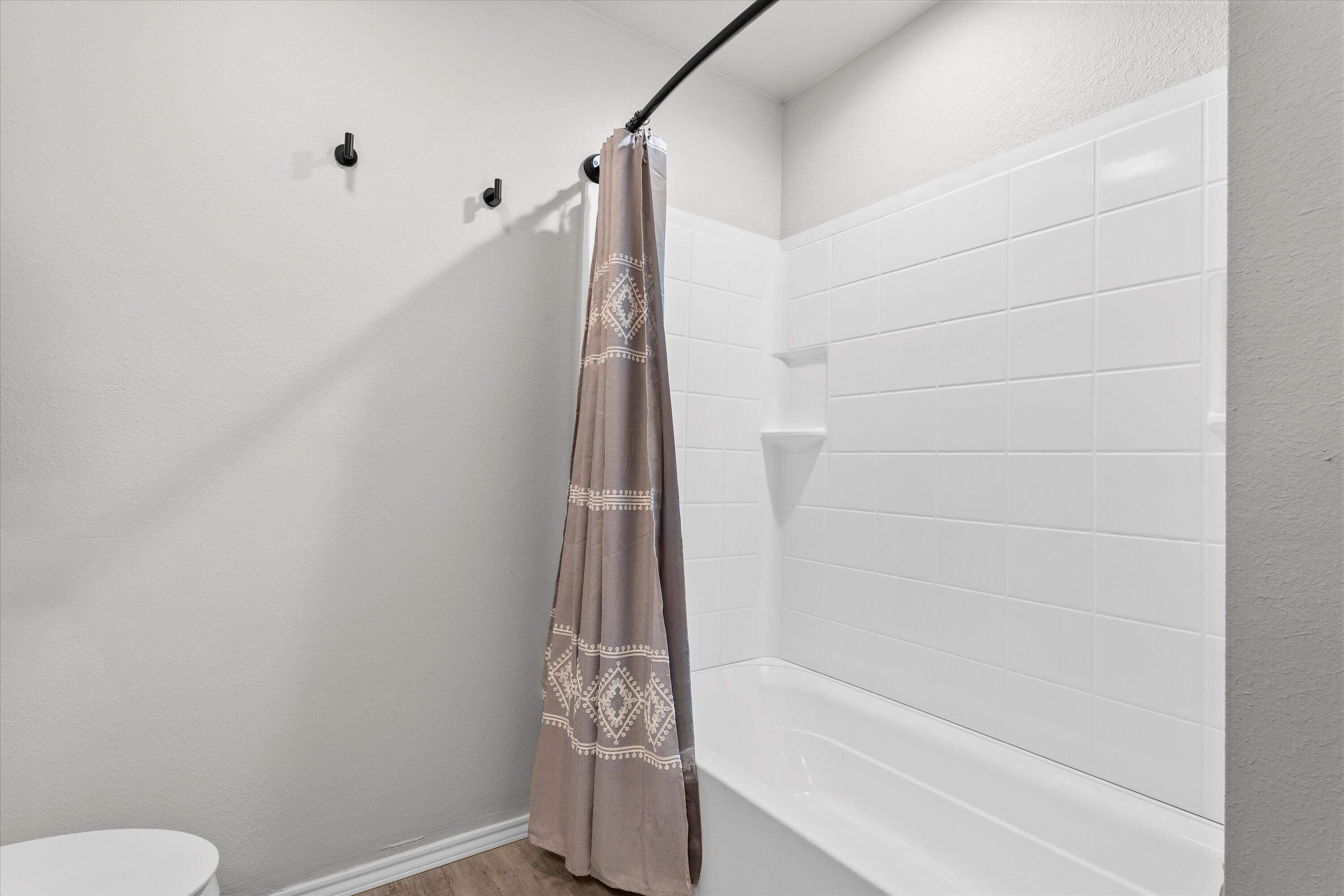 327 Hiracheta Drive New Home, TX 79381 - Photo 11 of 26 a bathroom with a shower and a toilet