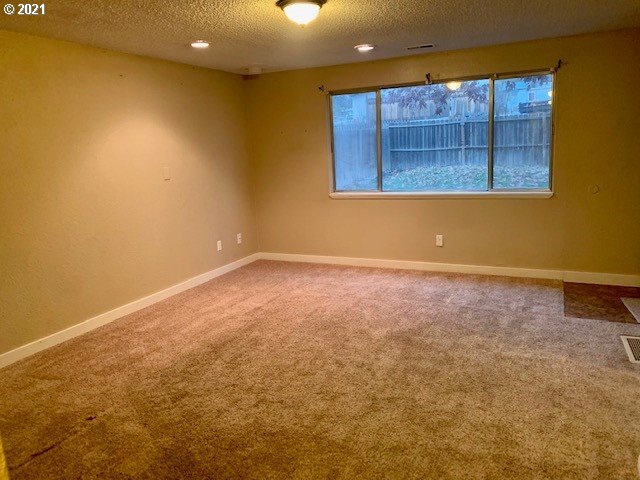 807 Southwest 14th Street Pendleton, OR 97801 - Photo 3 of 17 an empty room with wooden floor and windows