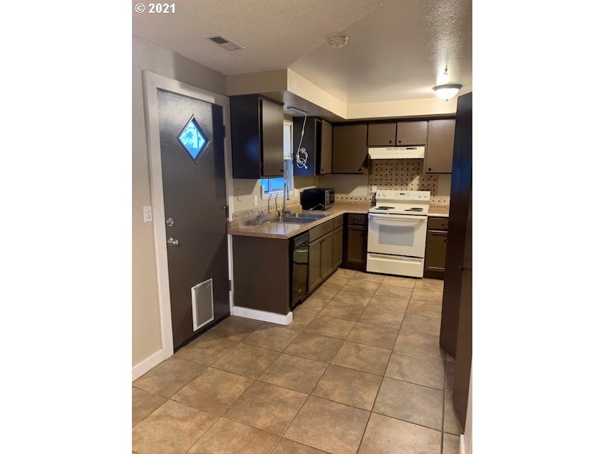807 Southwest 14th Street Pendleton, OR 97801 - Photo 6 of 17 a kitchen with stainless steel appliances granite countertop a sink and cabinets