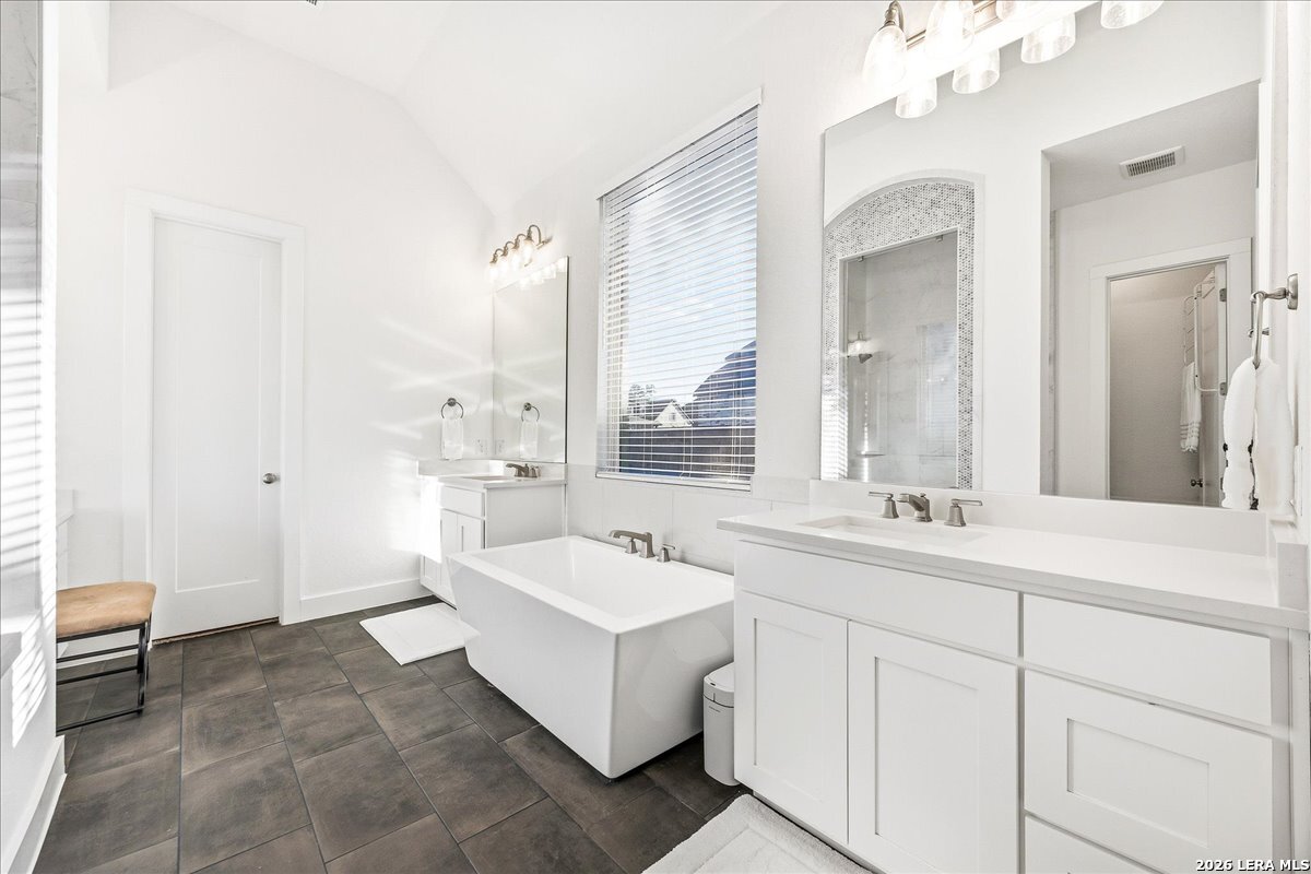 421 Corwin Springs Cibolo, TX 78108 - Photo 21 of 42 a spacious bathroom with a double vanity sink a mirror and a bathtub