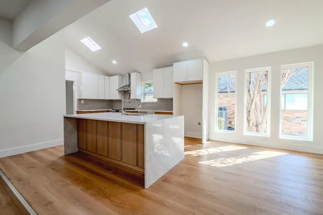 a kitchen with stainless steel appliances granite countertop a stove a sink and a refrigerator