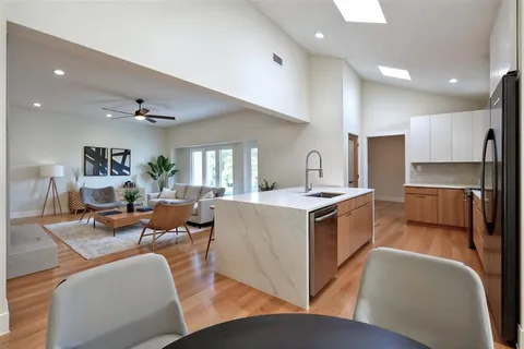 a living room with stainless steel appliances kitchen island granite countertop furniture and a view of kitchen