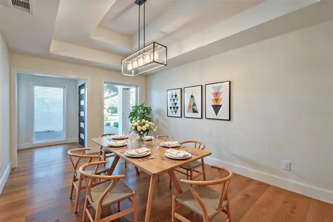 a view of a dining room with furniture a chandelier and wooden floor