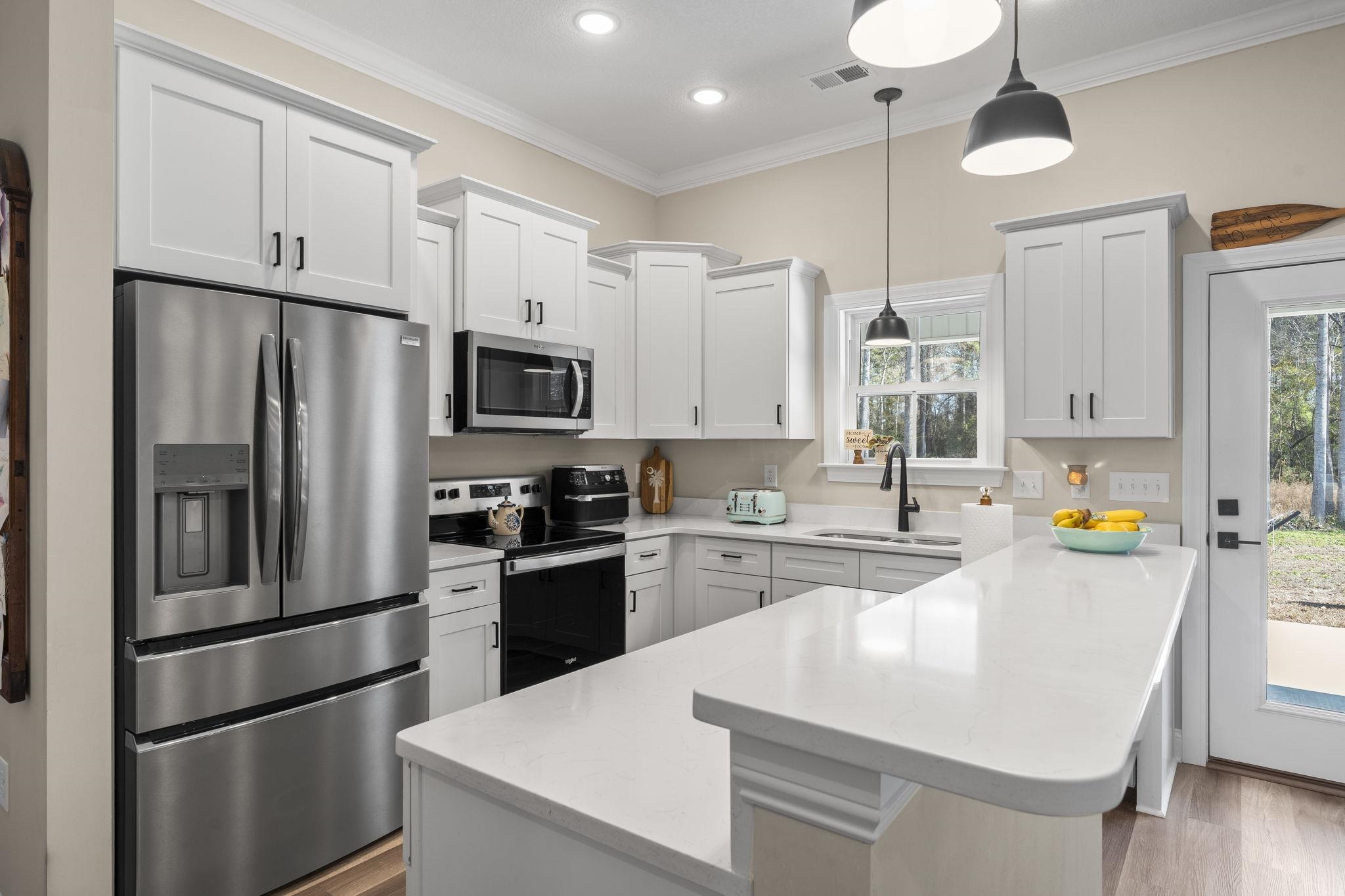 3394 Dusty Road Loris, SC 29569 - Photo 20 of 37 Kitchen with appliances with stainless steel finishes, decorative light fixtures, white cabinets, recessed lighting, and light stone countertops