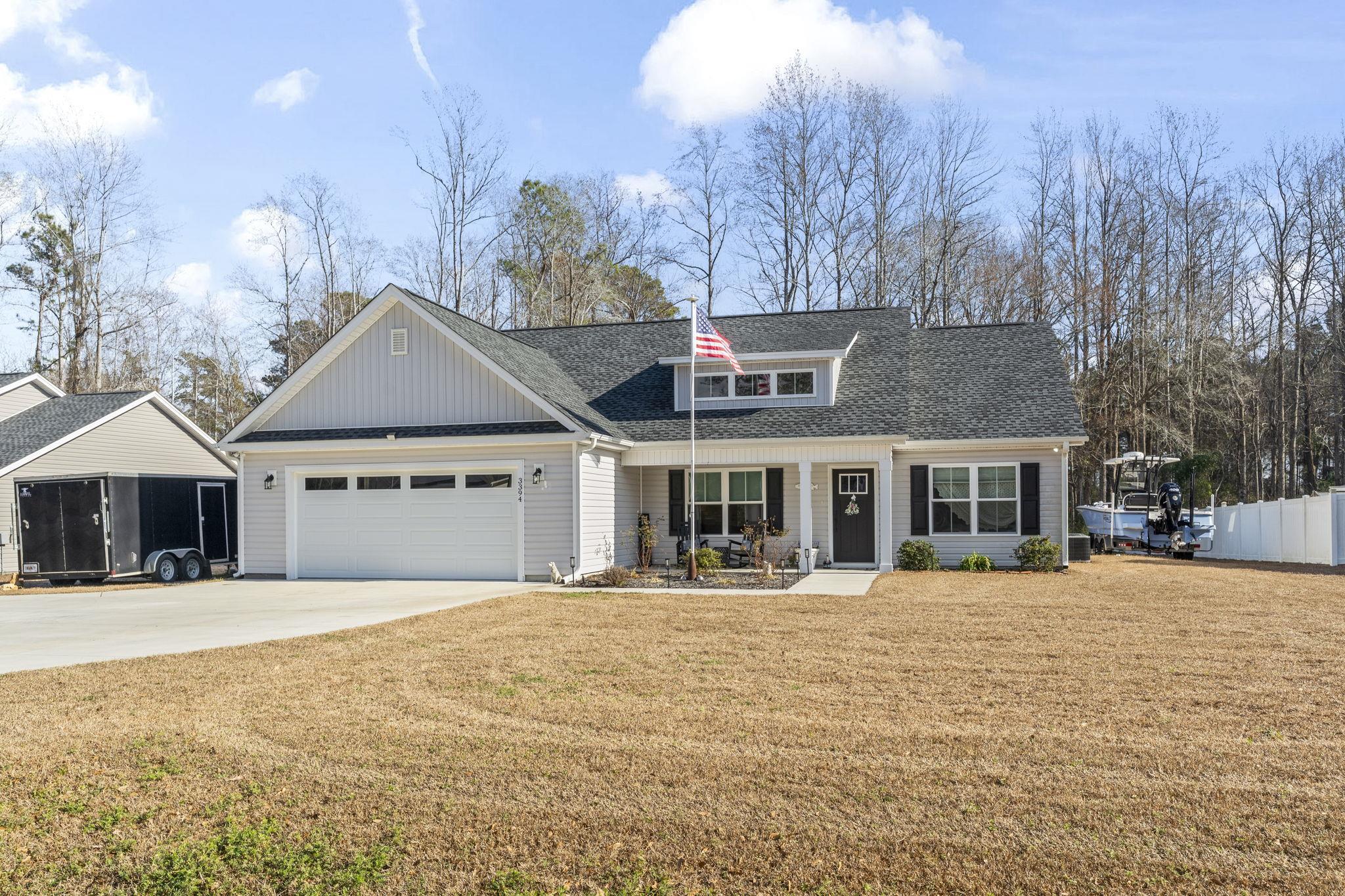 3394 Dusty Road Loris, SC 29569 - Photo 35 of 37 View of front of house with driveway, roof with shingles, covered porch, an attached garage, and board and batten siding