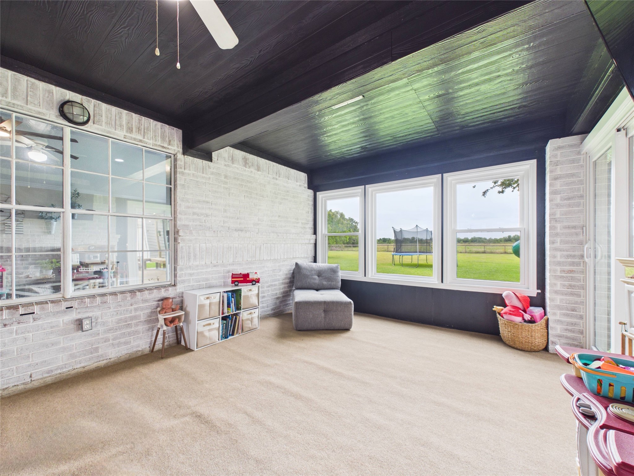 4610 Mustang Road Alvin, TX 77511 - Photo 26 of 50 Climate controlled sunroom/playroom with new windows and outdoor carpet. So many options for this space! New slider doors provide direct access to the backyard/back patio