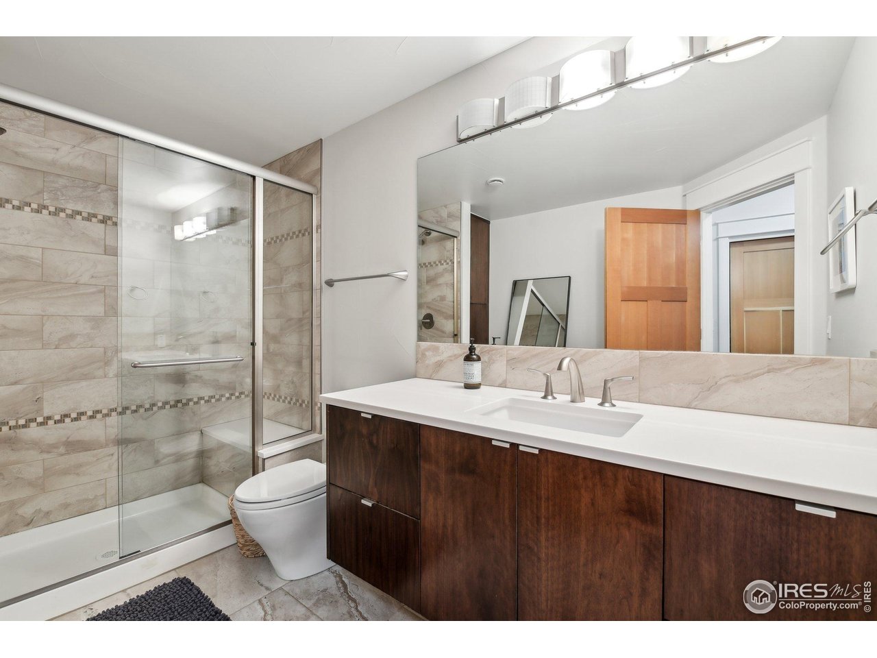 2917 13th Street Boulder, CO 80304 - Photo 26 of 40 a bathroom with a double vanity sink toilet mirror and shower