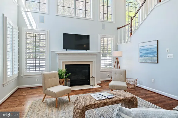 a kitchen with stainless steel appliances granite countertop a refrigerator a sink dishwasher a stove and white cabinets with wooden floor