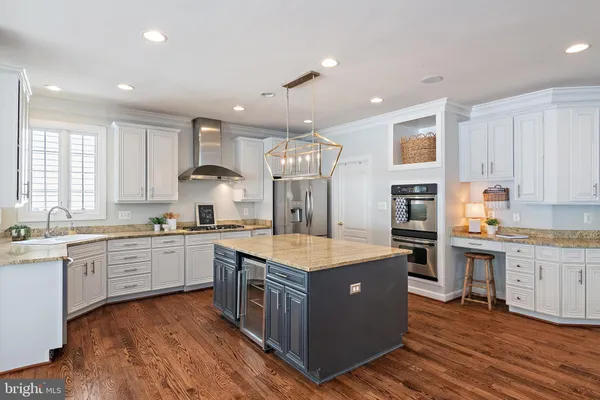 a kitchen with wooden floors and white cabinets