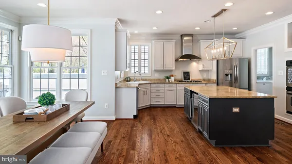 a kitchen with stainless steel appliances granite countertop a stove a sink and white cabinets