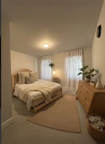 a spacious bedroom with a bed and a dresser