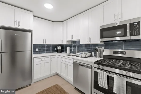 a kitchen with stainless steel appliances granite countertop a stove a refrigerator and a microwave