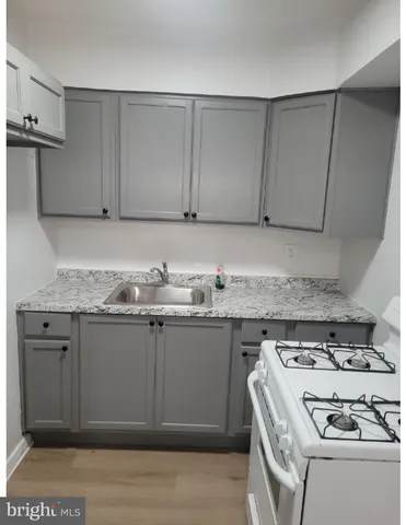 a view of a kitchen with granite countertop cabinets and a stove top oven