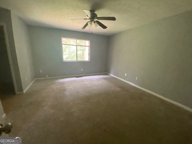 5389 Martins Crossing Road Stone Mountain, GA 30088 - Photo 13 of 30 en empty room with windows and chandelier fan