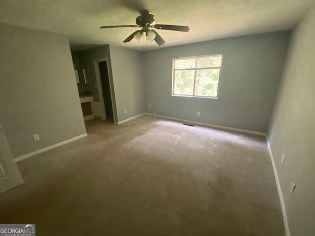 5389 Martins Crossing Road Stone Mountain, GA 30088 - Photo 14 of 30 en empty room with windows and ceiling fan