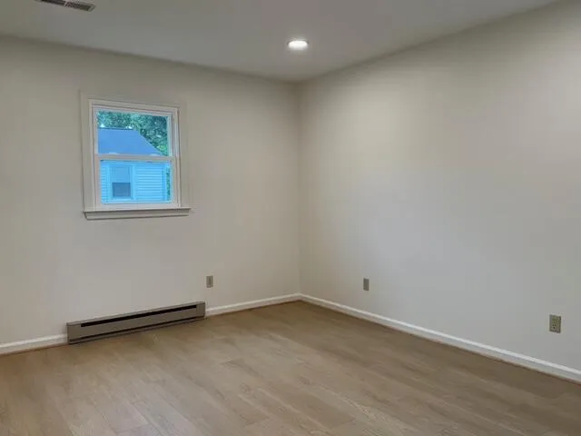 a view of a room with wooden floor and window