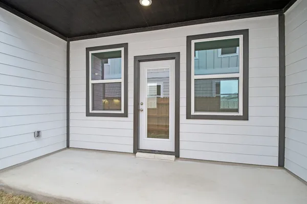 a backyard of a house with barbeque oven and brick wall