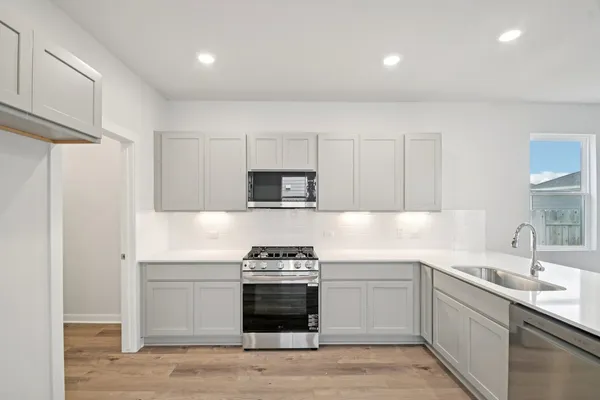 a kitchen with stainless steel appliances a stove sink and refrigerator