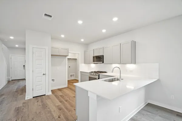 a kitchen with kitchen island a sink stainless steel appliances and cabinets