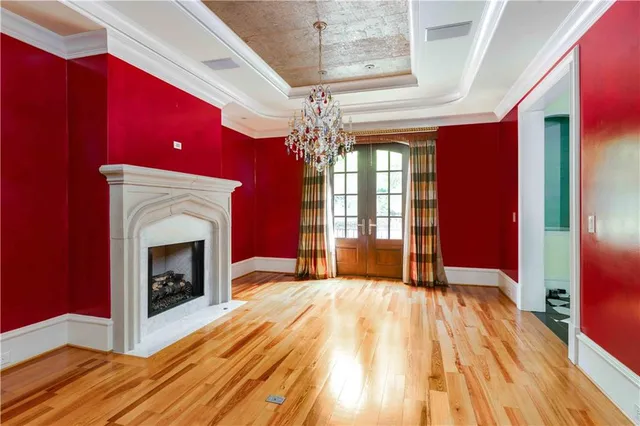 a view of a living room with wooden floor and a fireplace