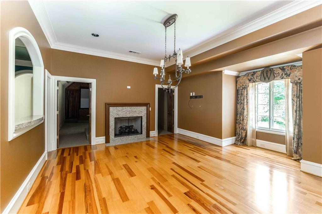 3558 Mill Creek Road Northeast Atlanta, GA 30319 - Photo 54 of 88 a view of an empty room with a fireplace and a chandelier