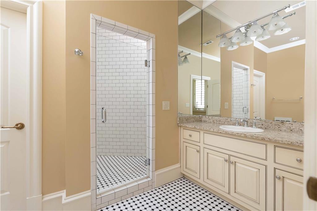3558 Mill Creek Road Northeast Atlanta, GA 30319 - Photo 74 of 88 a bathroom with a granite countertop sink a shower and a mirror