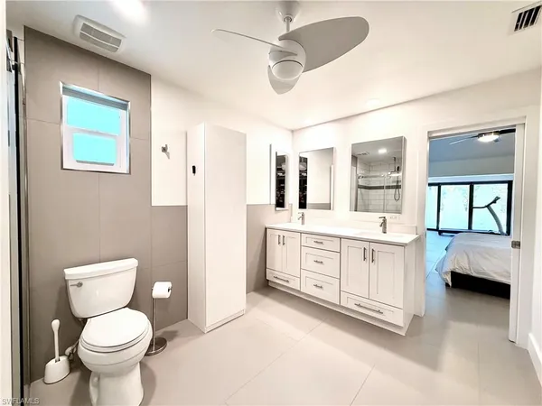 a bathroom with a granite countertop toilet sink and mirror