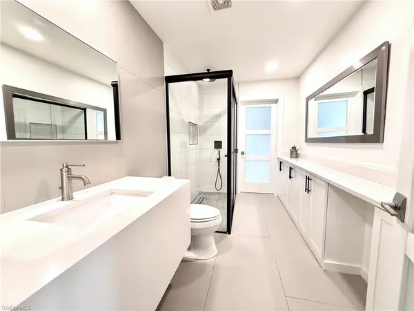 a spacious bathroom with a double vanity sink a mirror and a bathtub