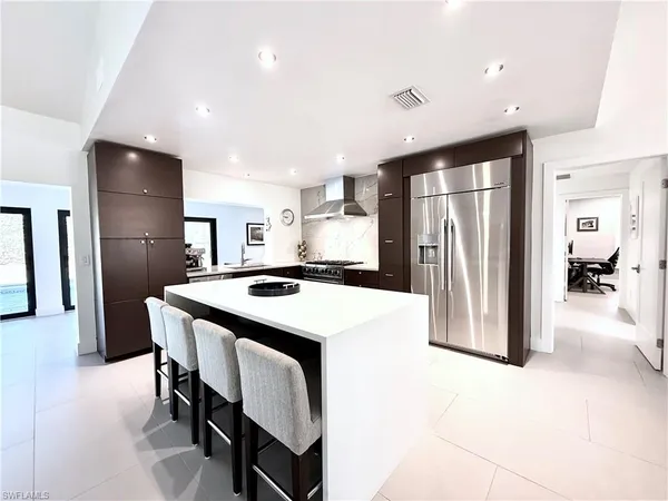a kitchen with refrigerator and chairs