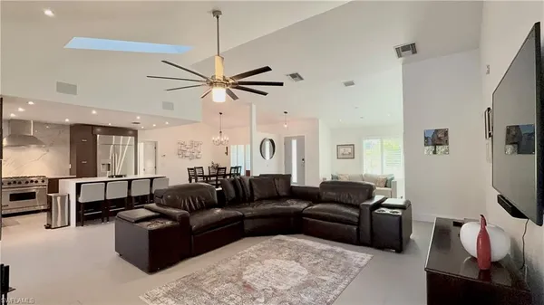 a living room with furniture a ceiling fan and a rug