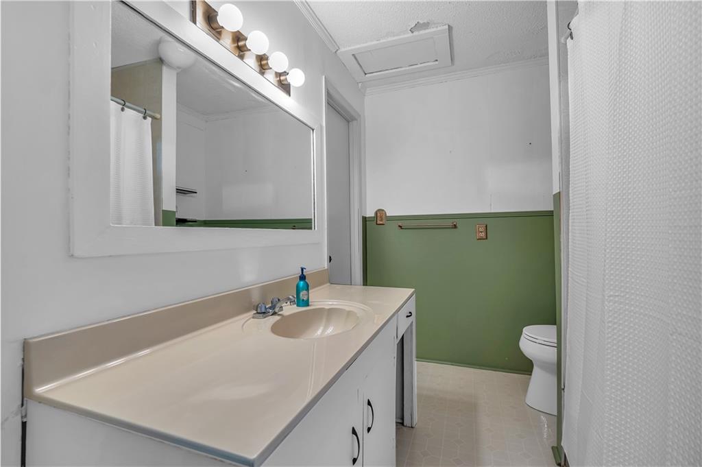 210 McCanless Street Cartersville, GA 30120 - Photo 14 of 27 a bathroom with a sink a toilet and a mirror