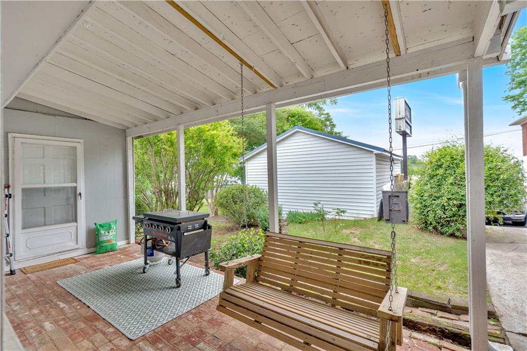 210 McCanless Street Cartersville, GA 30120 - Photo 24 of 27 a porch with a bench next to a yard
