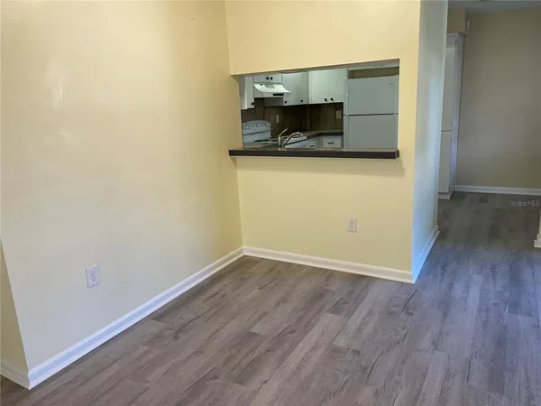 an empty room with wooden floor and fireplace
