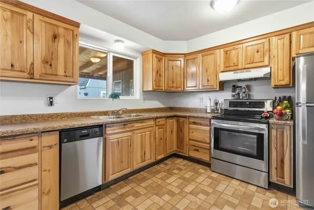 a kitchen with stainless steel appliances granite countertop a stove a sink and a microwave