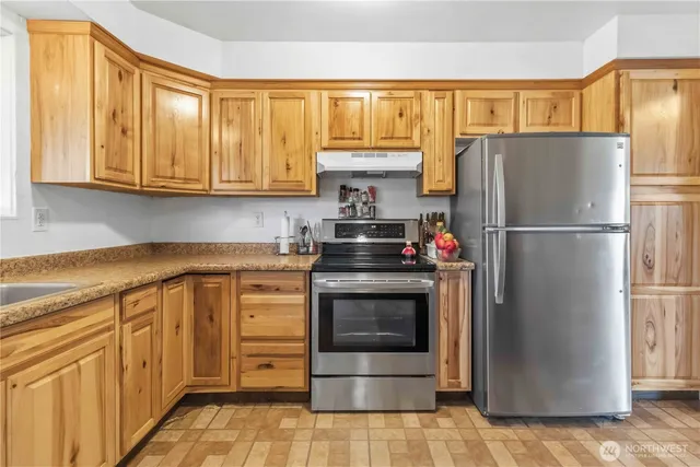 a kitchen with stainless steel appliances granite countertop a refrigerator stove and sink