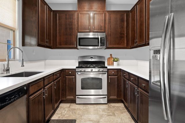 a kitchen with stainless steel appliances granite countertop a stove microwave and refrigerator